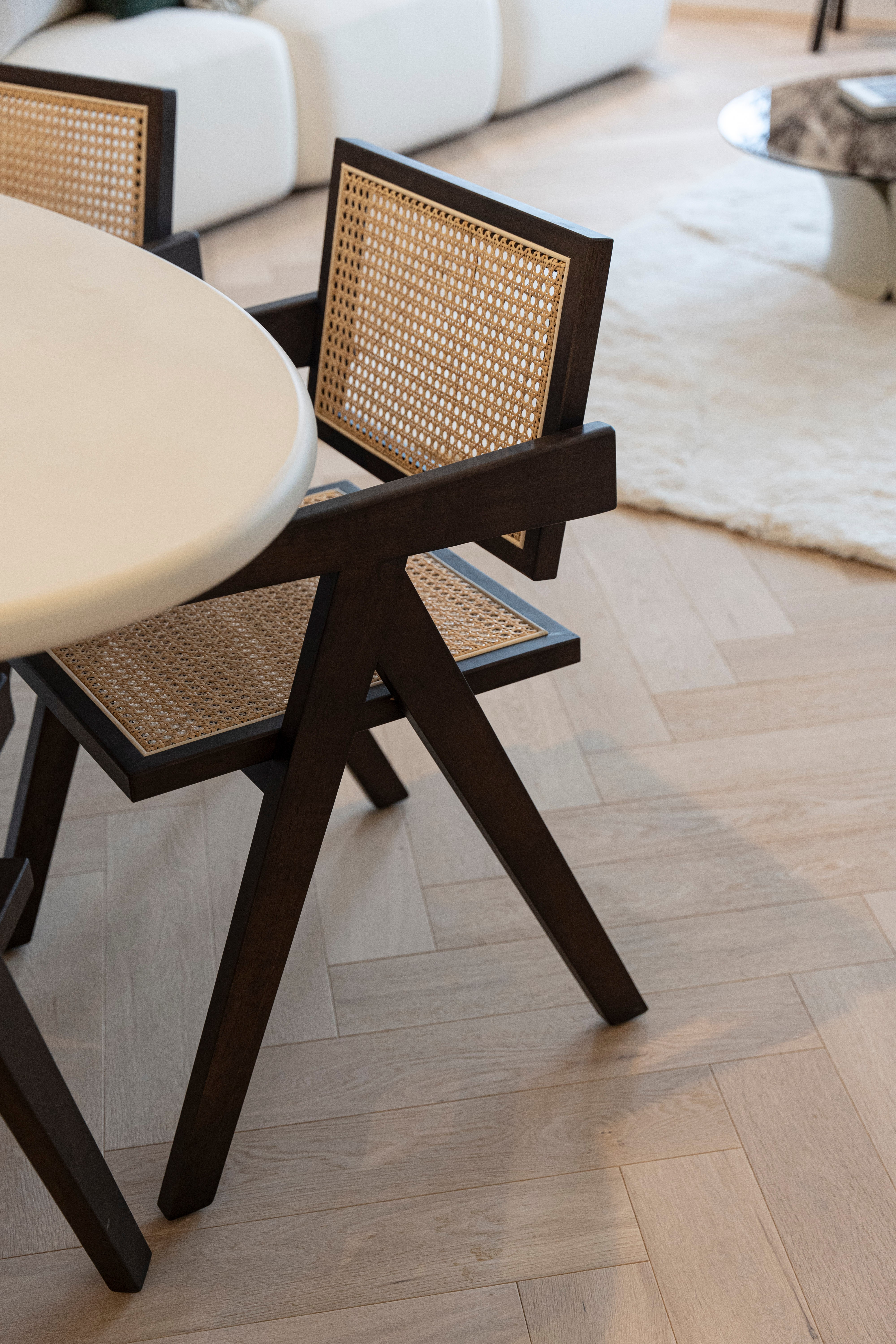 Herringbone oak flooring beneath a cane and dark wood dining chair, VOGUE Parquet