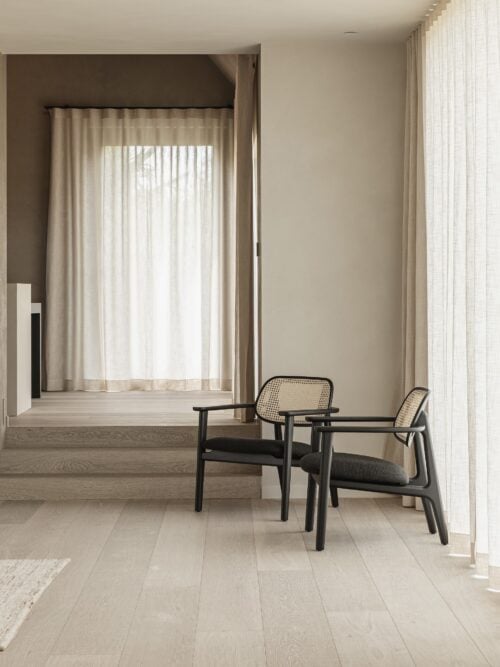 Wide plank dark French Oak floors with a hand-fumed finish, styled with linen drapery and bronze fixtures in a Coral Gables estate